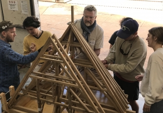 Group constructing wooden model indoors
