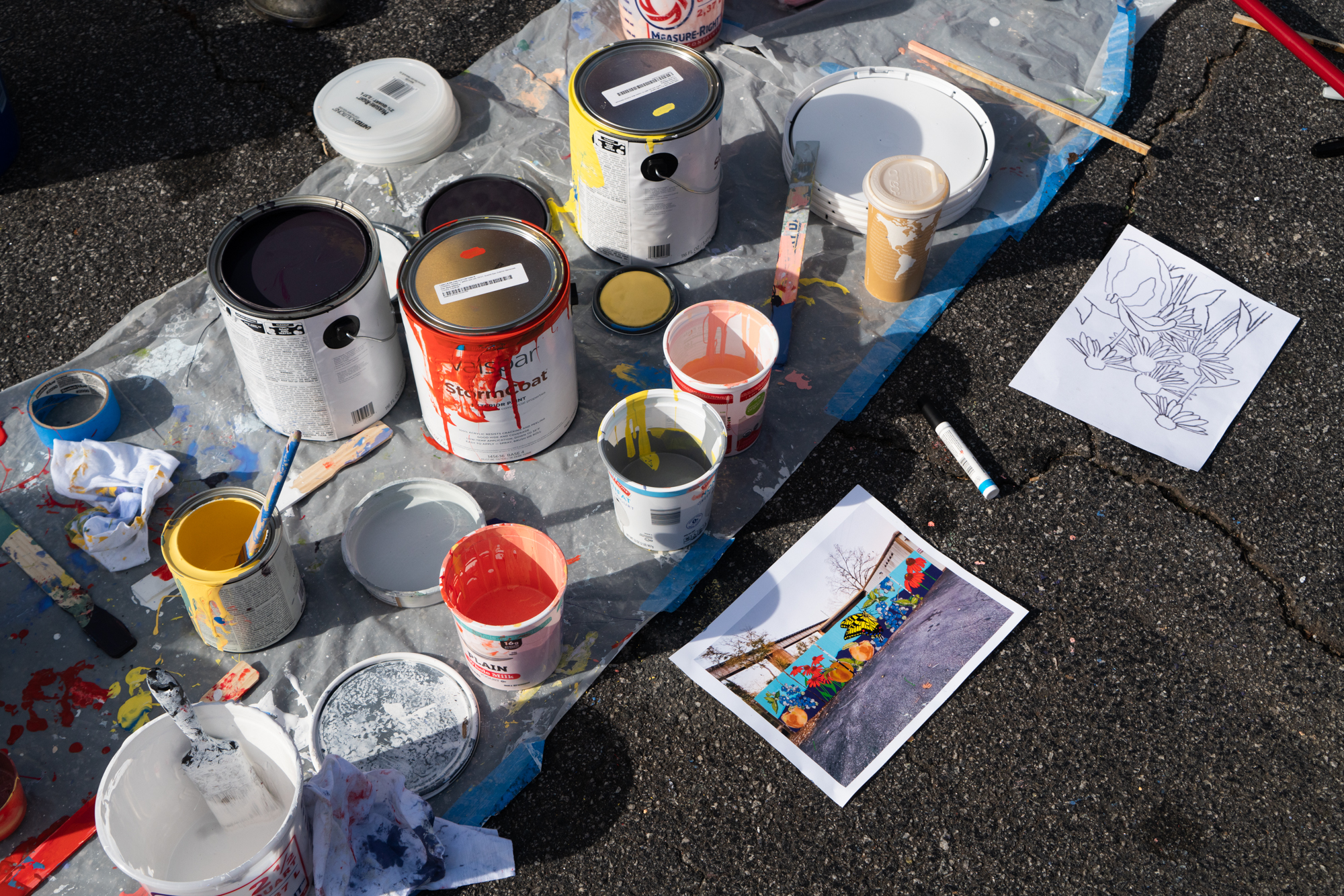 Photo: opened paint cans with a sketch of the mural design