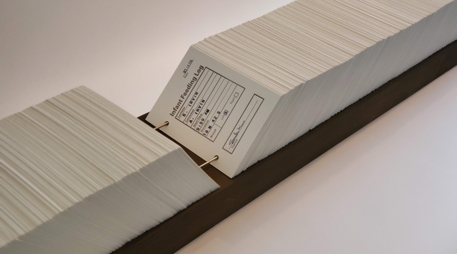 Sarah Irvin, (detail) Infant Feeding Log, 2018, Card catalogue with 2,400 unique platen-pressed cards, metal rods, wooden base, 7 x 78 1/4 inches