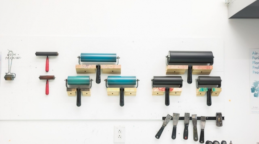 Print rollers hang on a wall in a classroom