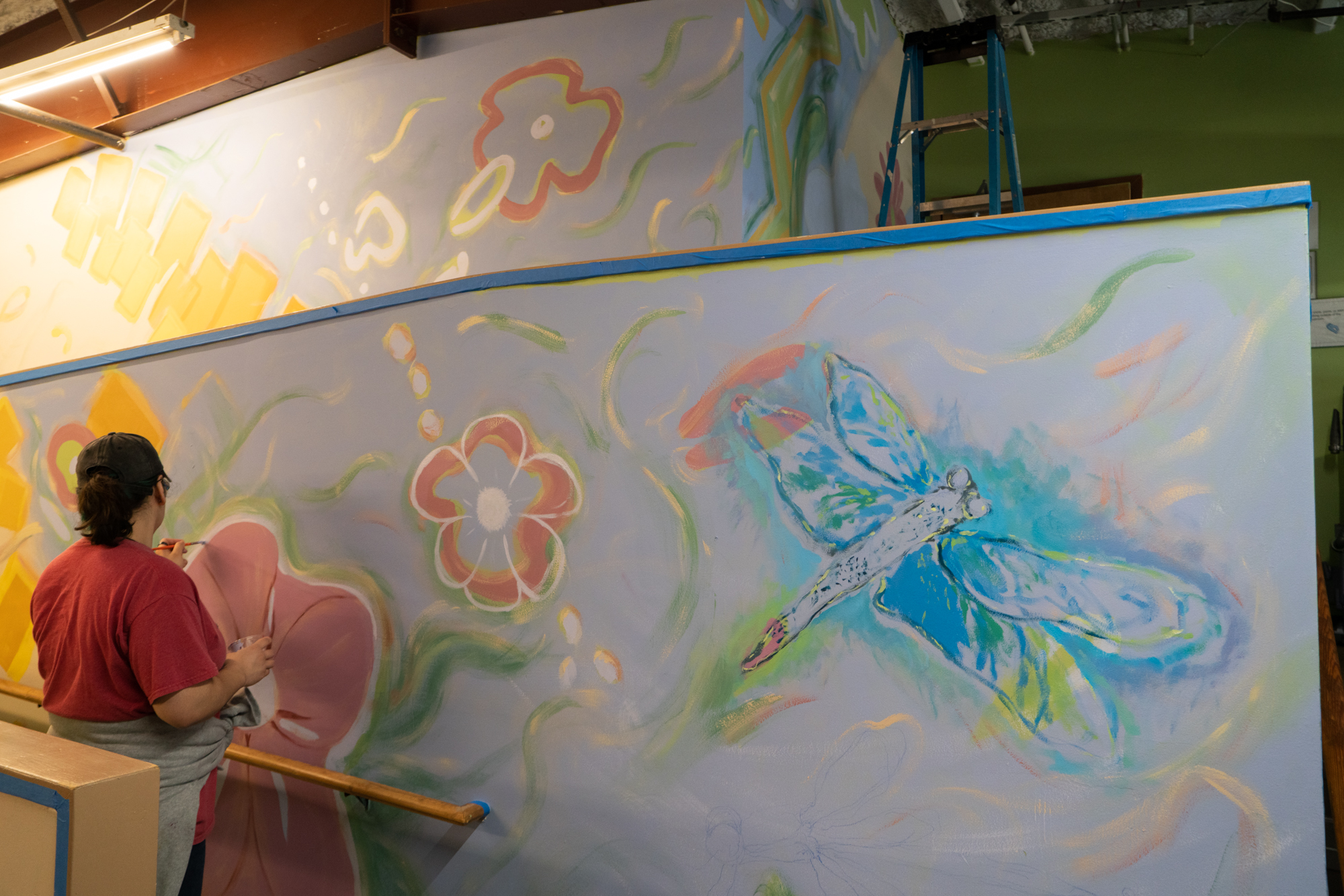 Photo: Volunteer in the early stages of painting interior mural