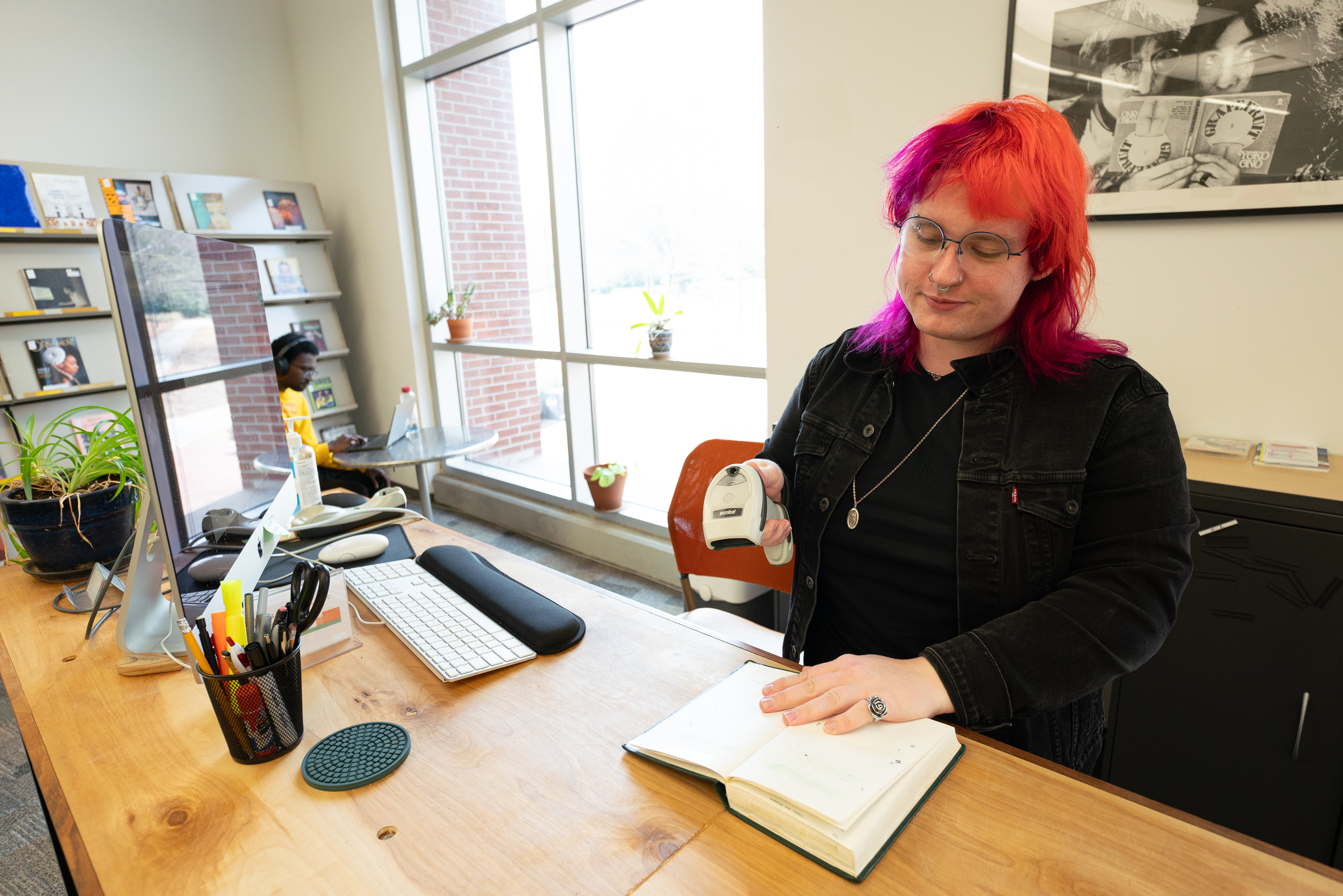 Art Library Coordinator Christee Henry checks out materials at the UGA Art Library circulation desk. Photograph courtesy of Sidney Chansamone.