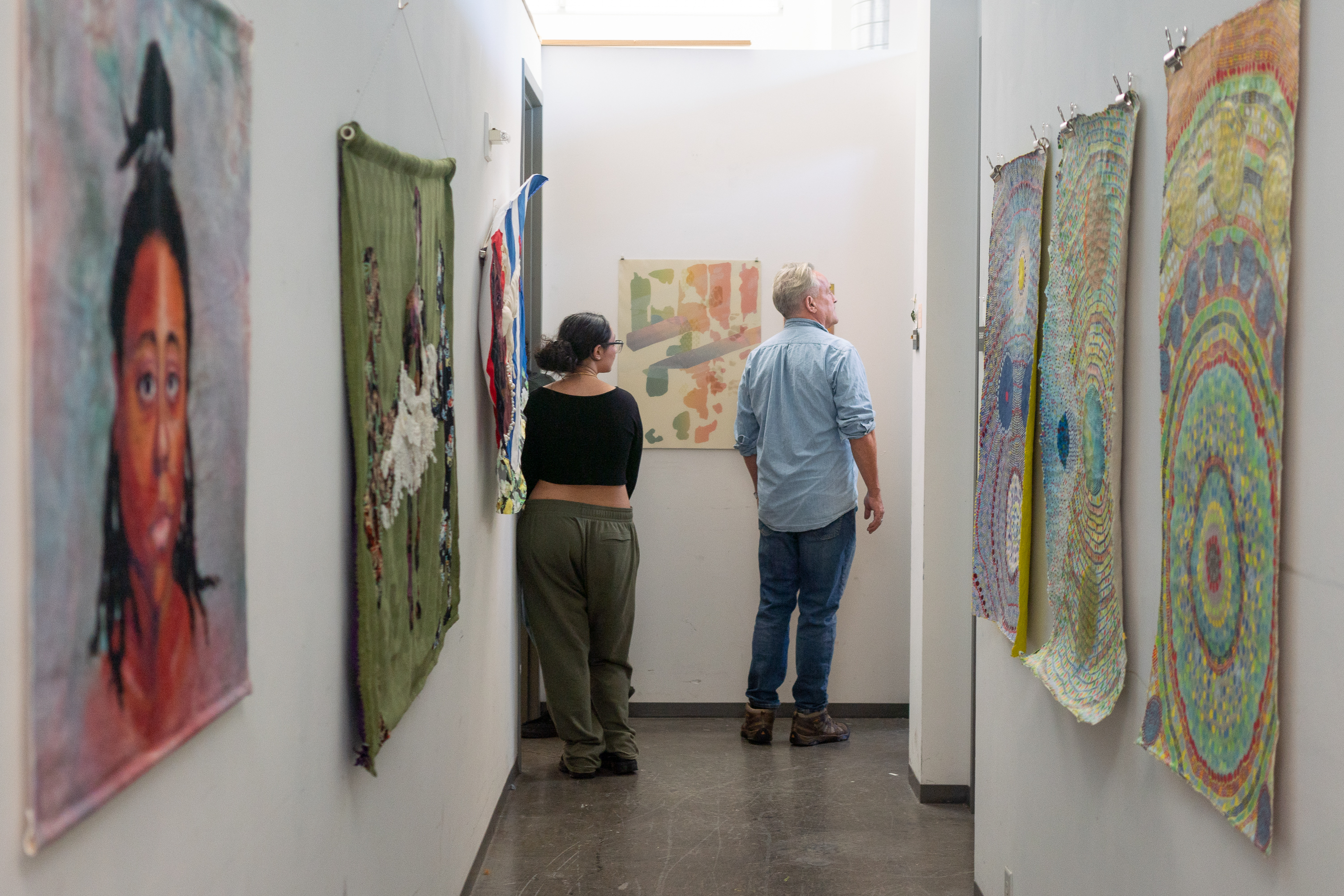 Two people in corridor viewing artworks on display
