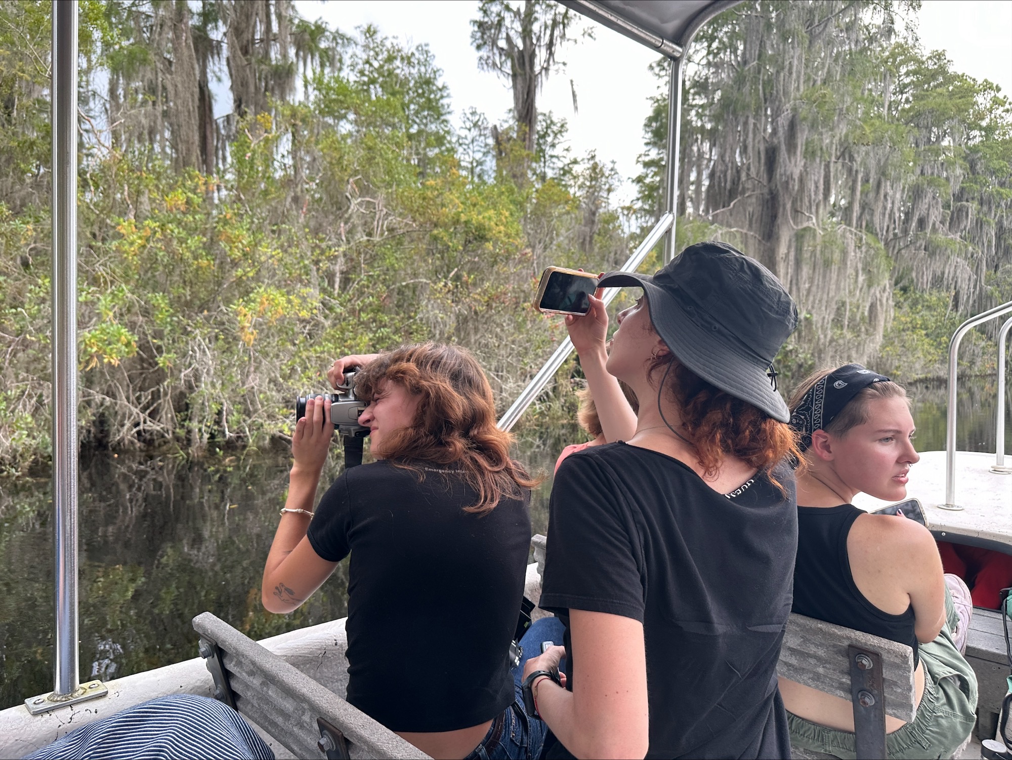 Students photographing shoreline onboard an Okefenokee Swamp boat tour