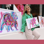 Chandler Sherry posing with colorful bulldog paintings
