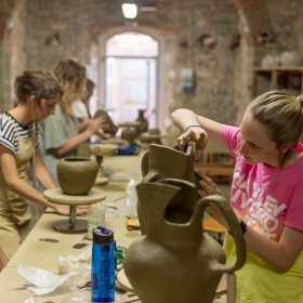 (L-R) Undergraduates Abby Hooper, Maggie Patten, and Caroline Clark work on their pieces in the ceramics studios in the John D. Kehoe Cortona Center.