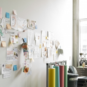 Indoor studio space with window and papers affixed to a wall