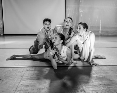 Black and white images of four dancers gathered around one another on the floor