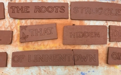 Words carved into brick: "The roots struggle that hidden of Linnentown"