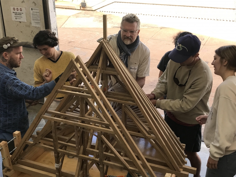 Group constructing wooden model indoors