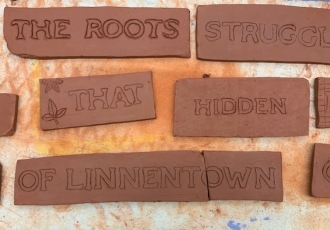 Words carved into brick: "The roots struggle that hidden of Linnentown"