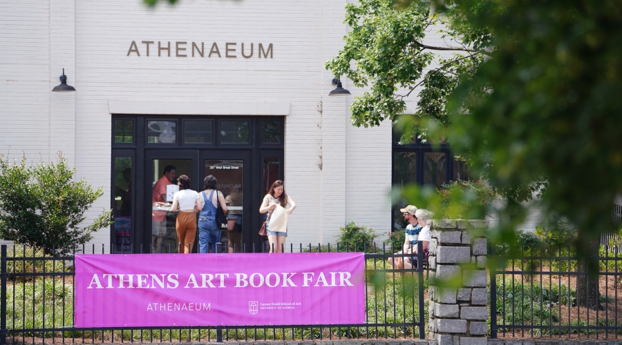 Exterior view of the Athens Art Book Fair at the Athenaeum gallery. Bright pink banner hanging on railing says the name of the event. Image courtesy of Sidney Chansamone