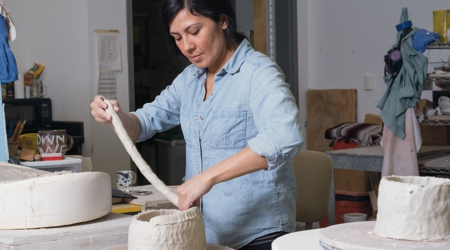 A student working on a piece of pottery