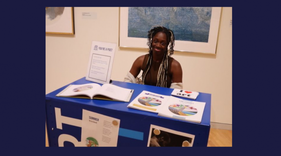 Seated person smiling in front of table with promotional materials