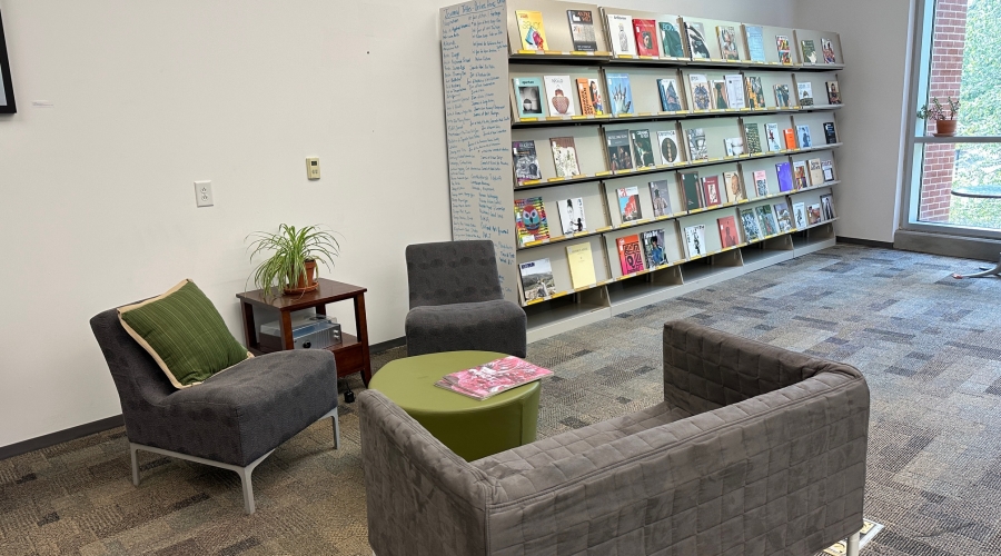 An image of the seating area with two chairs and a couch. A small green table is situated in the center of the seating area with two copies of the periodical The Brooklyn Rail visible on the table.