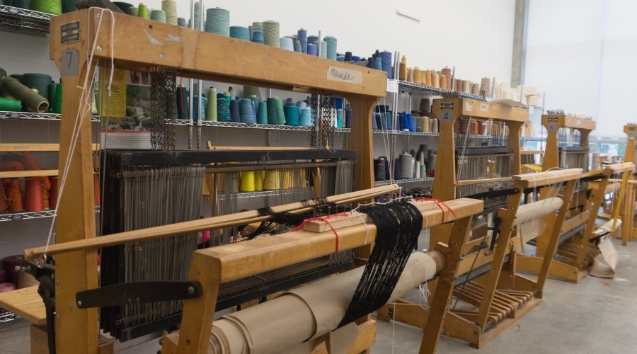Multiple looms sit in a row 