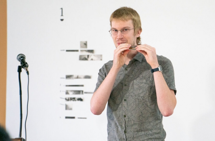 Daniel Karcher, DMA in music composition, was the grand prize winner at last year’s Four Minutes 33 Seconds Competition. His presentation about sonic spatialization in music composition included a live demonstration with a harmonica. (Photo by Sidney Chansamone)