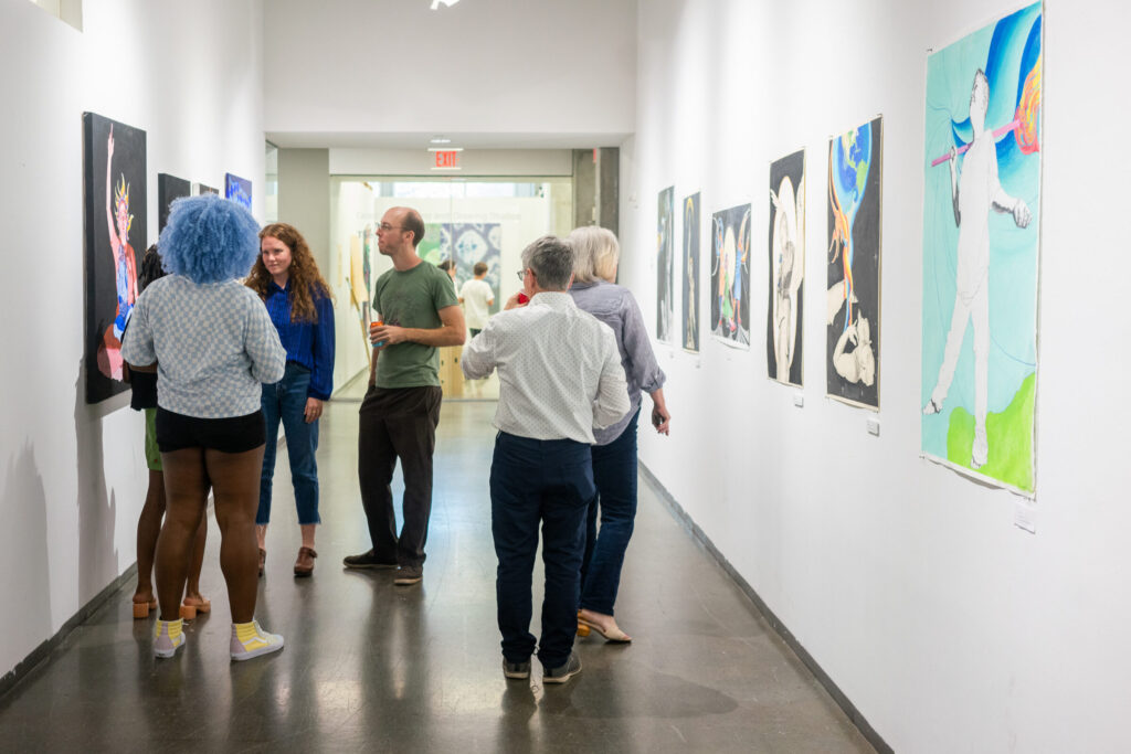 Guests mingle in the third floor hallway on the south wing of the School of Art near graduate studio spaces.