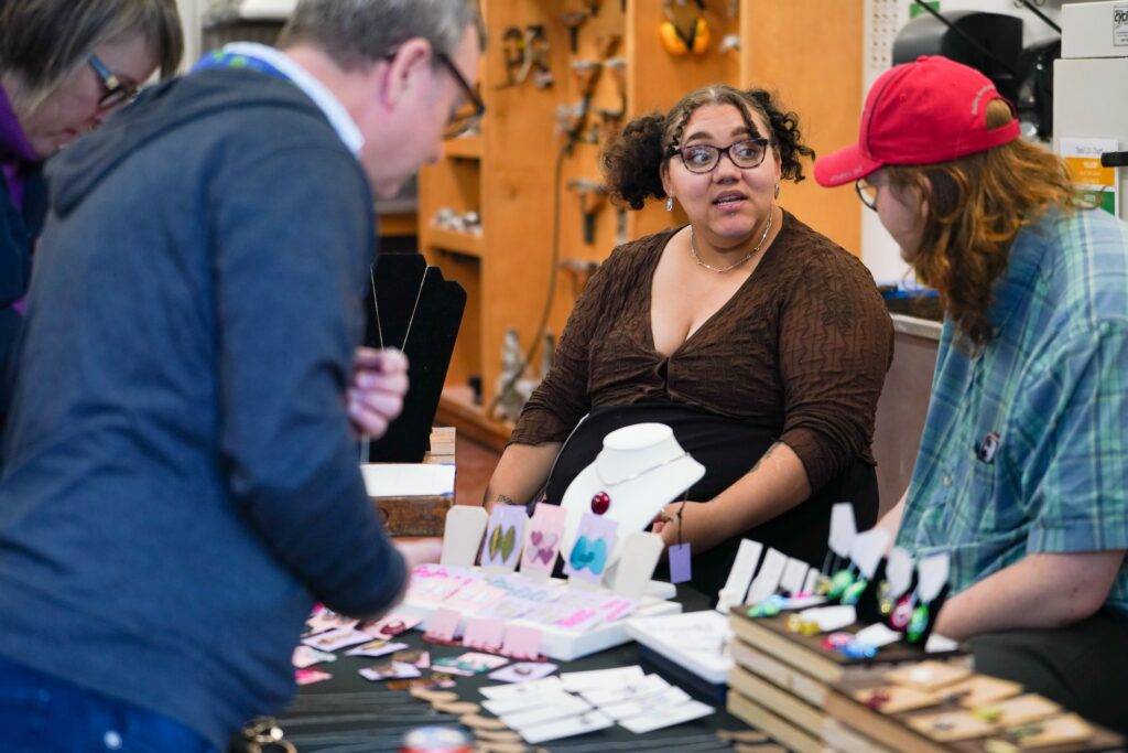 Students and visitors gathered around table with jewelry for sale. Phi Beata Heata, a jewelry and metalwork organization at the Lamar Dodd School of Art, hosted a sale and auction to raise funds for travel to New York City Jewelry Week this fall. 