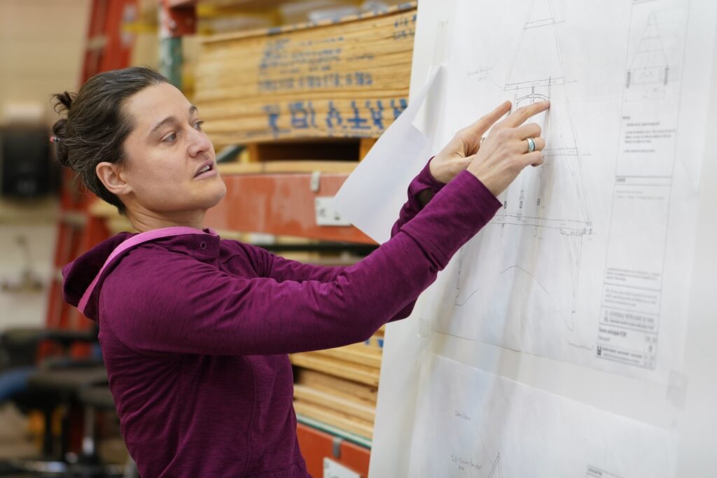Marie Brown, executive director of Handshouse Studio, indicating truss element in architectural drawings used for the Notre Dame de Paris Truss Project. Photo by Sidney Chansamone, @sid.chansa 