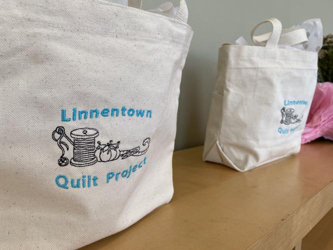 Tote bags sit on a shelf at the Linnentown Quilt Project's quilt reveal on April 10, 2022 at the Georgia Museum of Art in Athens, Georgia. A small crowd gathered to view the quilt, then took a tour of the museum's community-centered works. 