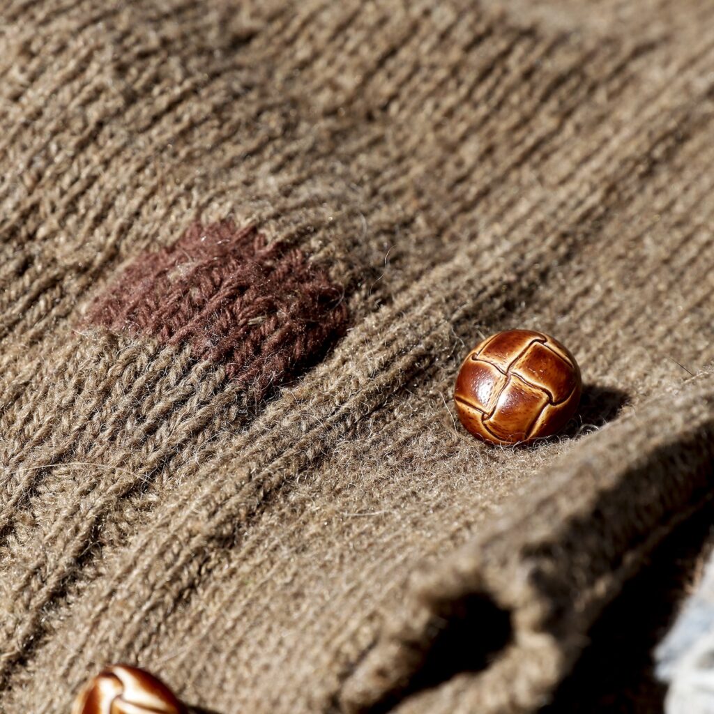 A patch knitted on a vintage wool sweater to fix a hole.
